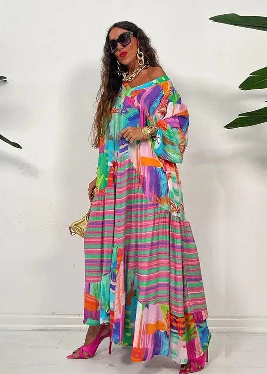 Woman wearing a colorful striped dress with a white background and green plants.