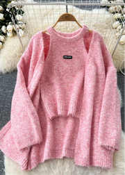 Pink sweater on a hanger with a blurred decorative background