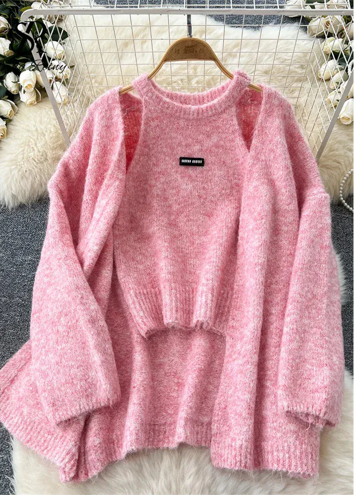 Pink sweater on a hanger with a blurred decorative background