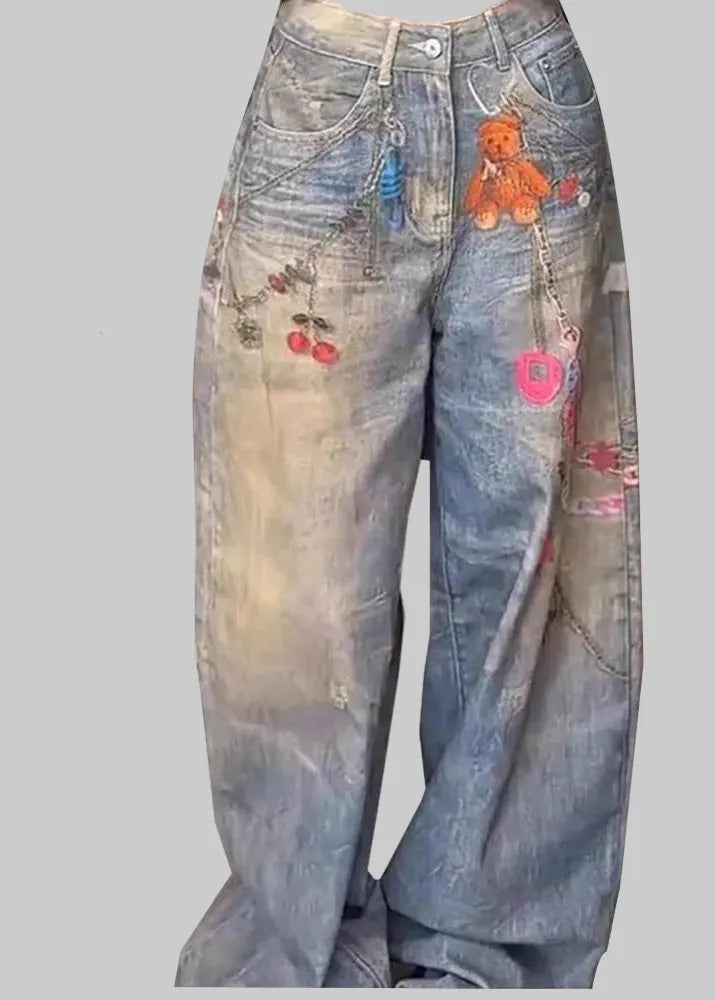 Blue jeans with various patches and a teddy bear design on a white background.