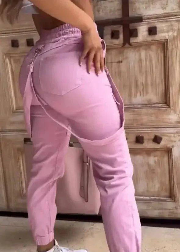 Person wearing pink pants standing in front of a wooden door.