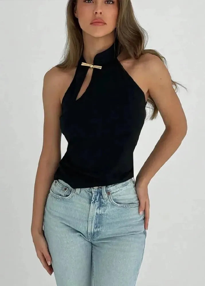 Woman wearing a black halter top and light blue jeans against a white background