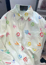 White shirt with colorful geometric patterns on a blurred background
