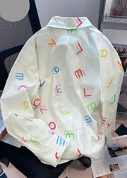 Light-colored jacket with colorful letter patterns on a chair.