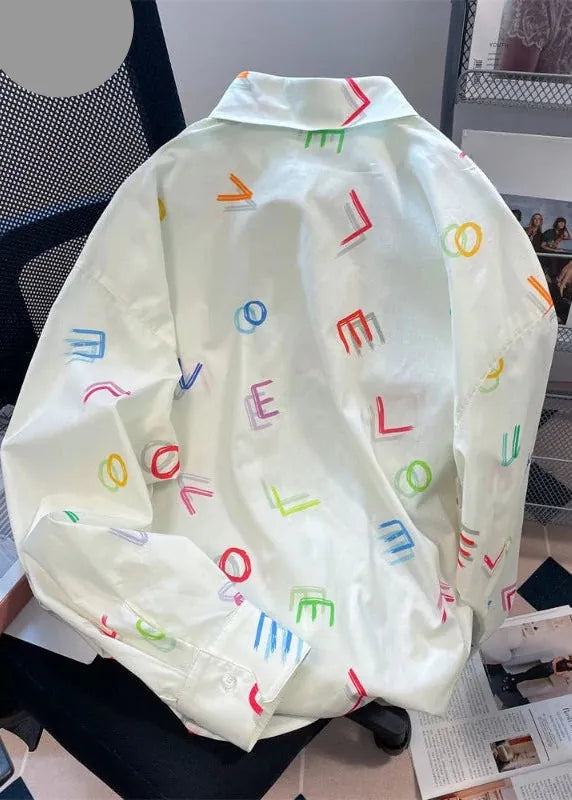 Light-colored jacket with colorful letter patterns on a chair.