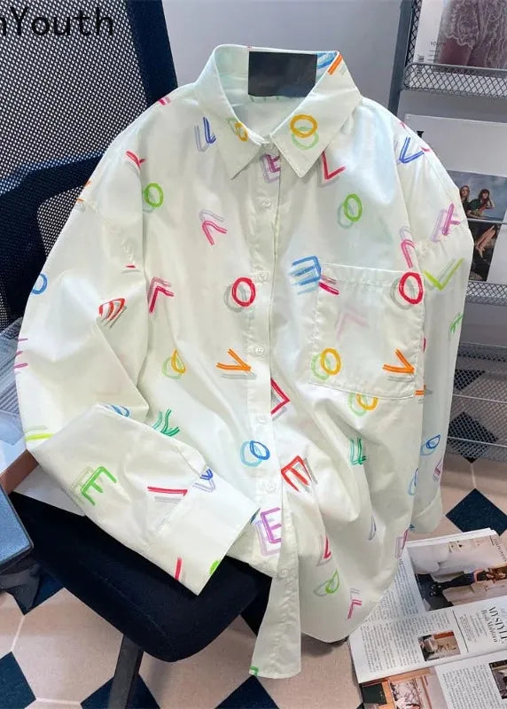 White shirt with colorful letter patterns on a chair in an office setting