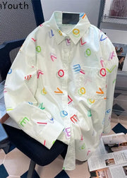 White shirt with colorful letter patterns on a chair in an office setting