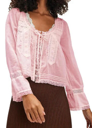 Pink lace top worn by a model on a white background
