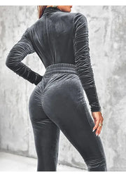 Person wearing a gray velvet outfit with a blurred background