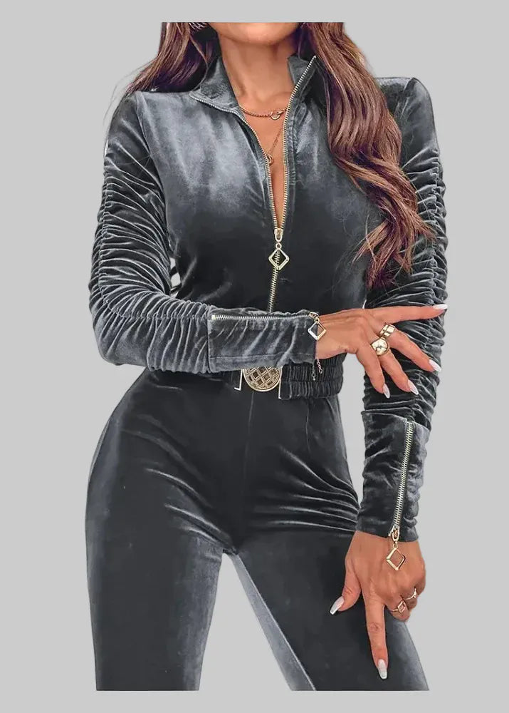 Person wearing a gray velvet outfit with a zipper on a gray background