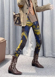 Person wearing patterned leggings and brown boots with a checkered jacket and handbag.