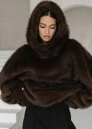 Woman wearing a brown fur hooded wrap against a neutral background