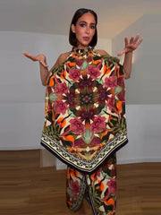 Woman wearing a colorful patterned outfit in a room with wooden floor and white walls.