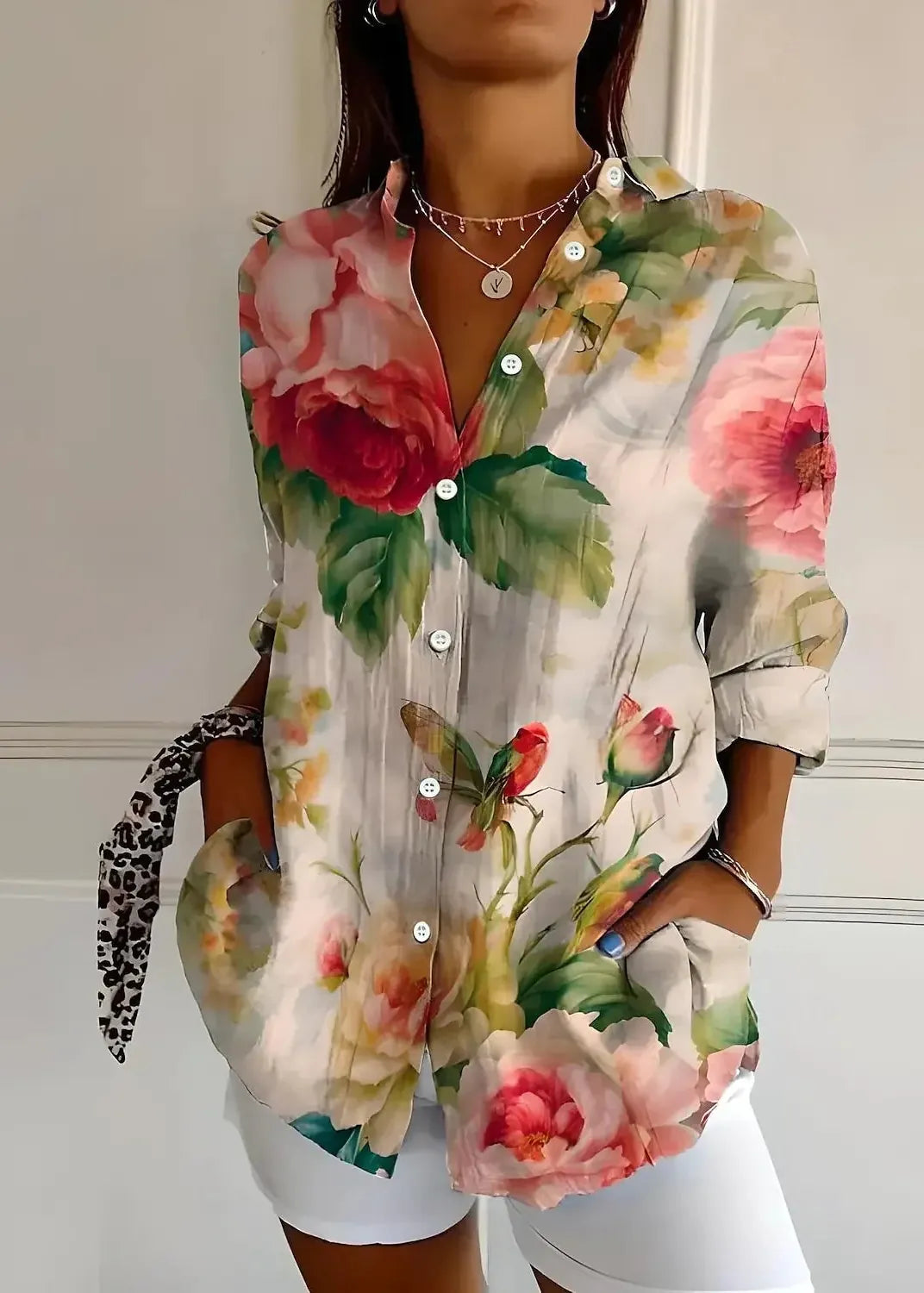 Woman wearing a floral blouse with a neutral background