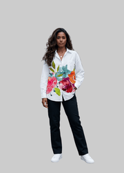 Woman wearing a colorful floral blouse and black pants on a city street with 'arvin' branding.