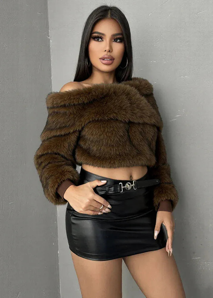 Woman wearing a brown fur jacket and black leather skirt against a gray background