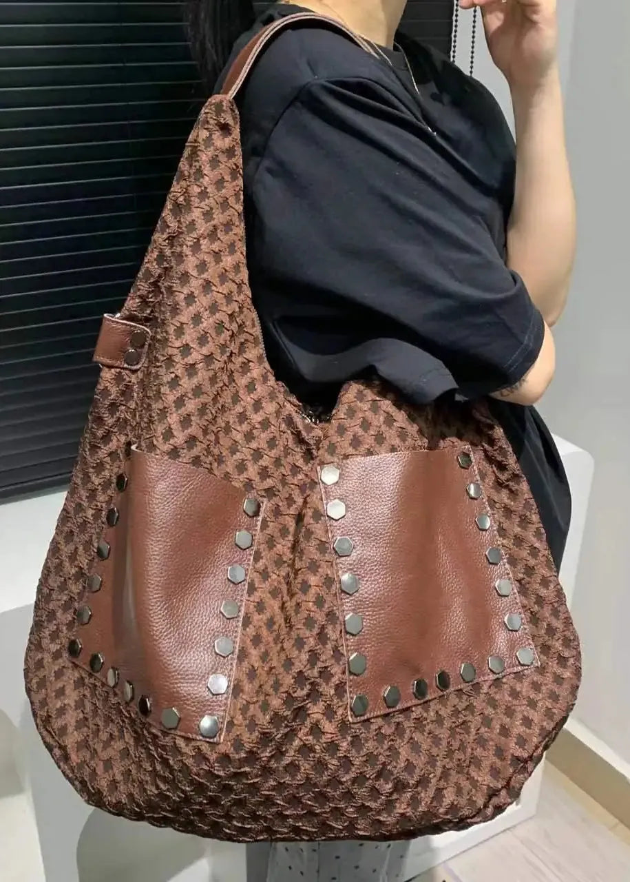 Person holding a brown leopard print bag with studs.