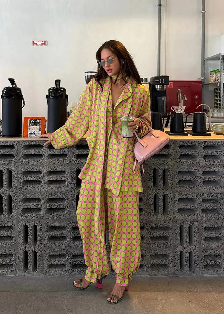 Woman in a bright yellow patterned outfit standing in a modern kitchen.