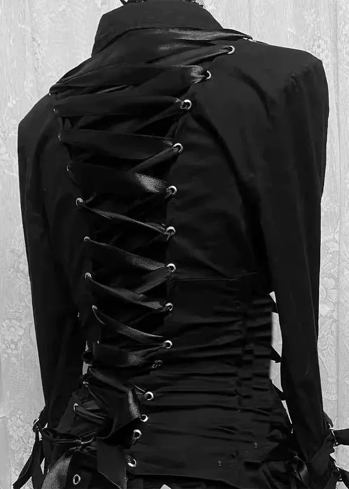 A black long-sleeve gothic-style top or dress shown from the back, featuring a high collar, sheer lace-up back panels with silver metal eyelets, and a ruched corset-style waist, photographed against a light patterned curtain.