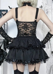 Person wearing a black lace dress with floral details in a decorative setting.