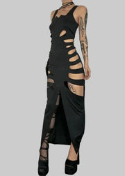 Person wearing a black gothic-style dress with cut-out design against a plain background