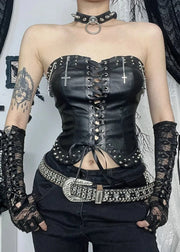 Person wearing a black leather corset with studded details and lace gloves.