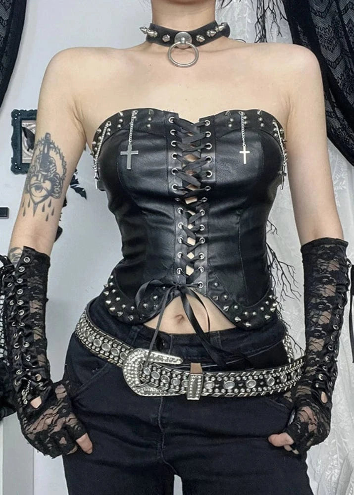 Person wearing a black leather corset with studded details and lace gloves.