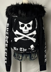 Black hoodie with skull and crossbones design on a mannequin against a plain background