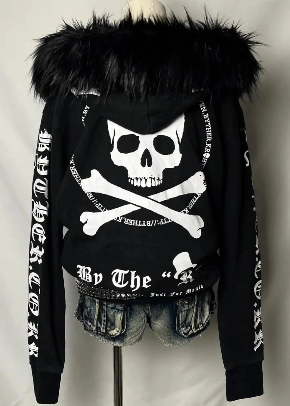 Black hoodie with skull and crossbones design on a mannequin against a plain background