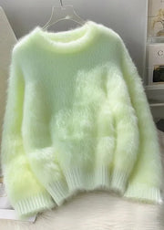 Light green fluffy sweater on a hanger against a neutral background