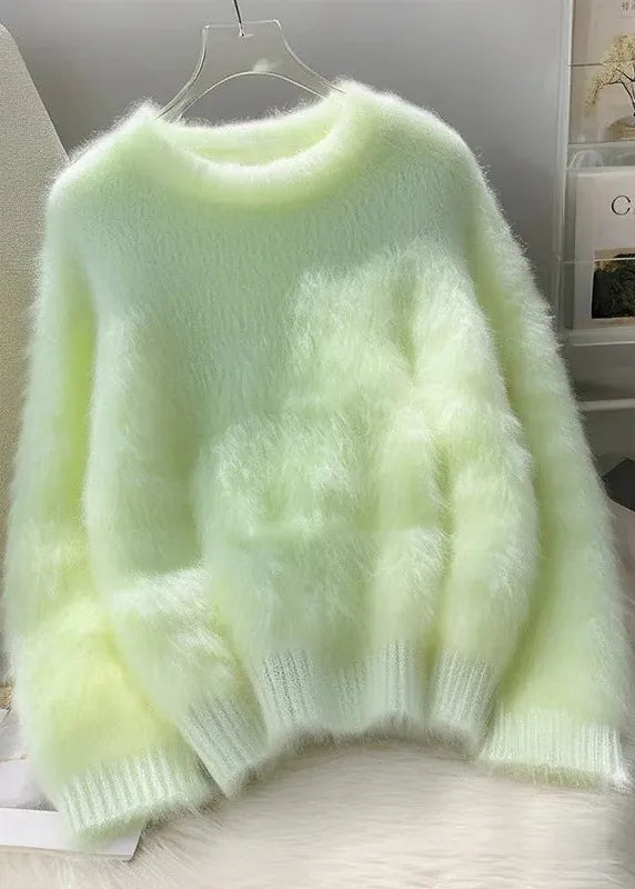 Light green fluffy sweater on a hanger against a neutral background