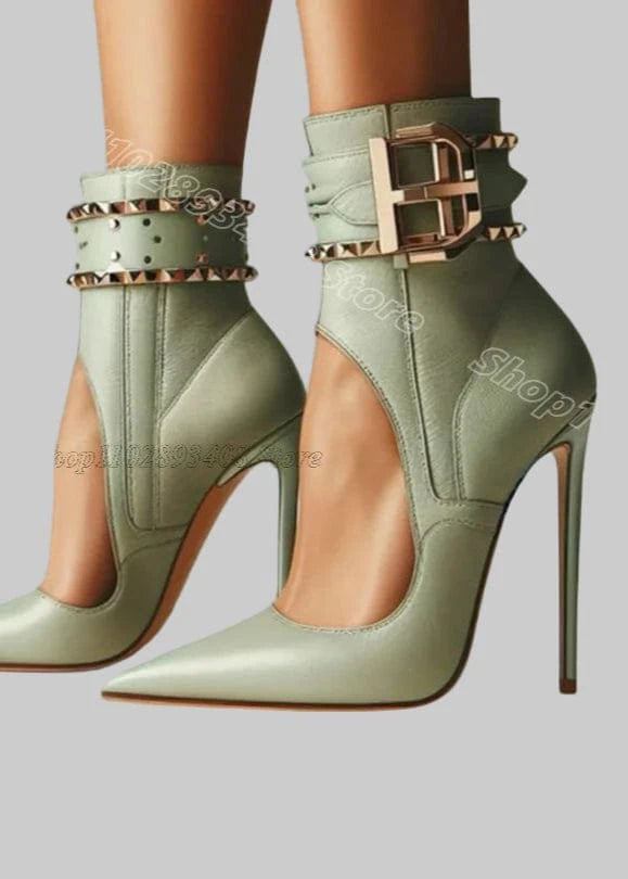Green high-heeled shoes with decorative straps on a light blue background