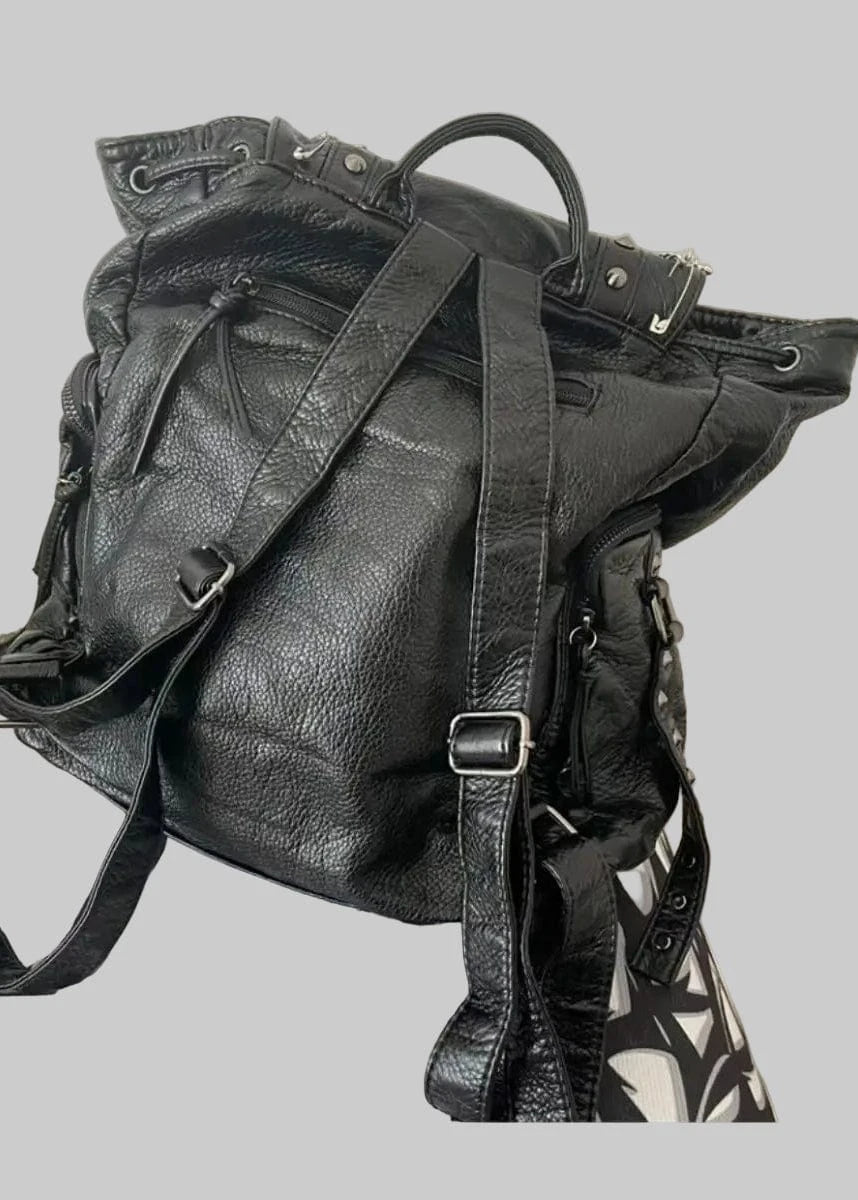 Black leather backpack on a patterned surface