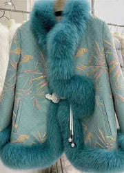 A turquoise blue embroidered jacket with a large fluffy faux fur collar, cuffs, and hem, featuring gold and pink bamboo patterns, displayed on a hanger rack.