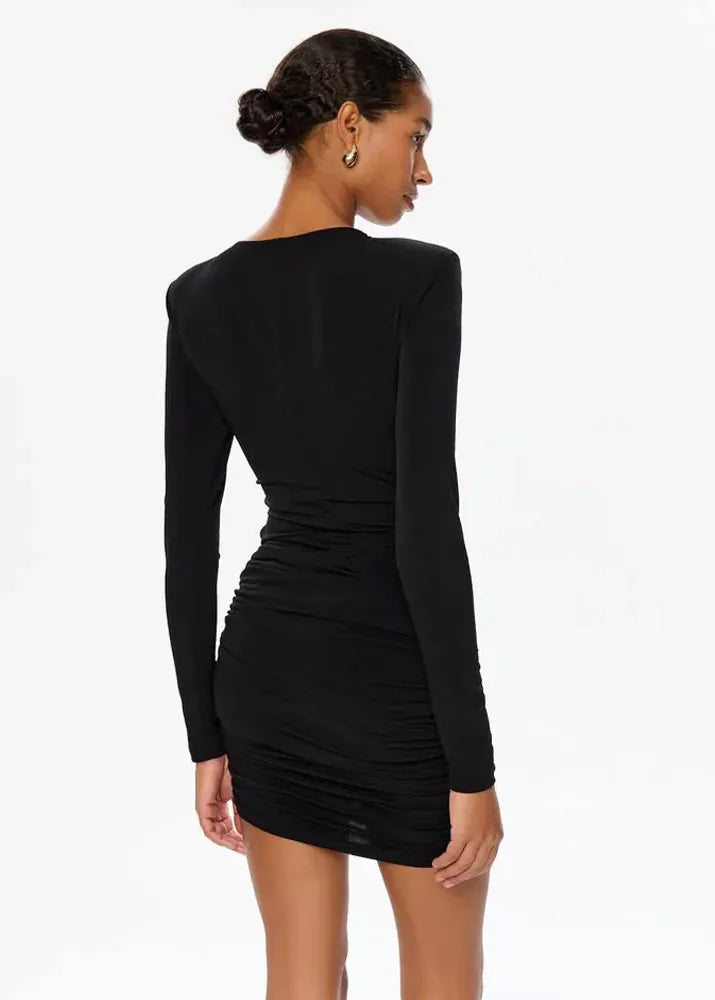 Woman wearing a black long-sleeve dress on a white background