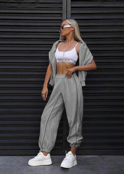 Woman in athletic wear standing against a dark metallic background