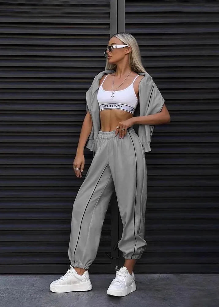 Woman in athletic wear standing against a dark metallic background