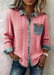Person wearing a pink cable knit shirt with denim accents on a light background