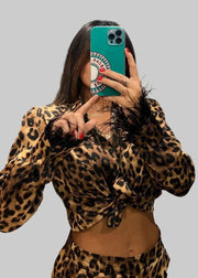 Person wearing a leopard print outfit taking a mirror selfie.