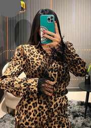 Person wearing a leopard print outfit taking a mirror selfie.