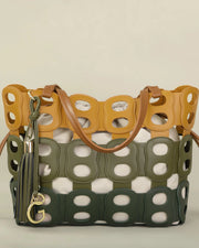 Designer handbag with cut-out pattern and visible brand logo on a beige background