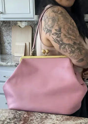 Person holding a pink handbag in a kitchen setting