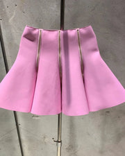 Pink skirt on a mannequin against a gray concrete wall