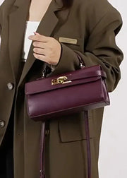 Person holding a purple handbag with a plain background