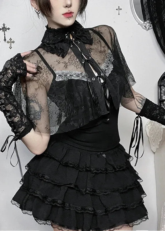 Person wearing a black lace outfit with a white background