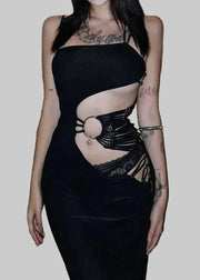 Person wearing a black dress with cut-out design on a textured floor.