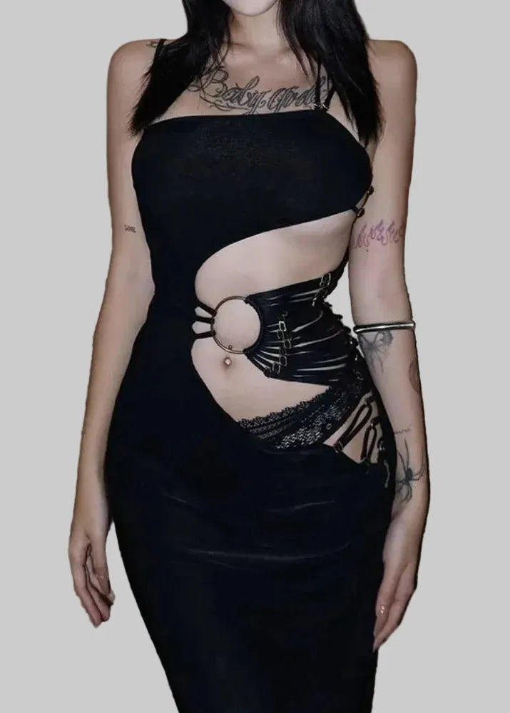 Person wearing a black dress with cut-out design on a textured floor.