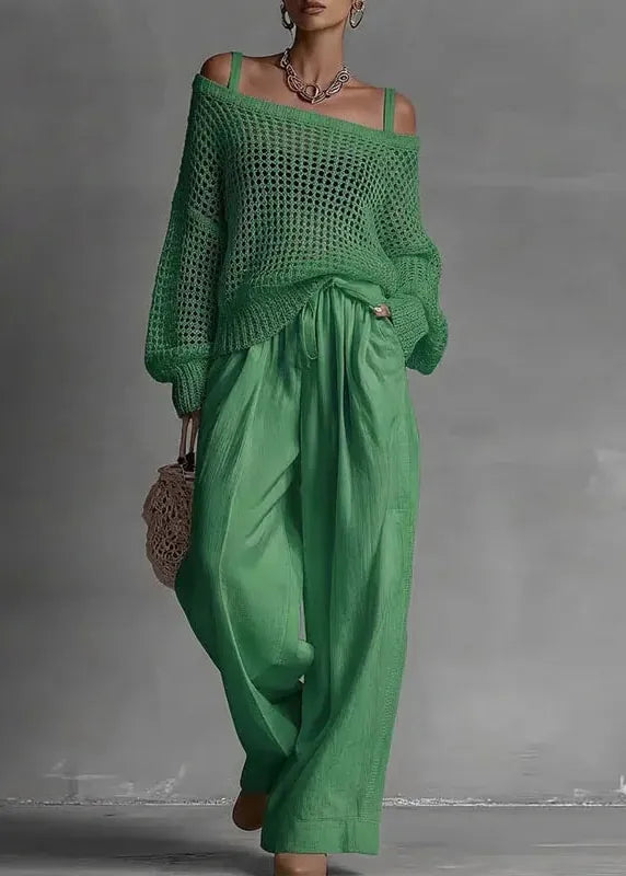 Person wearing a green outfit with wide-legged pants against a gray background
