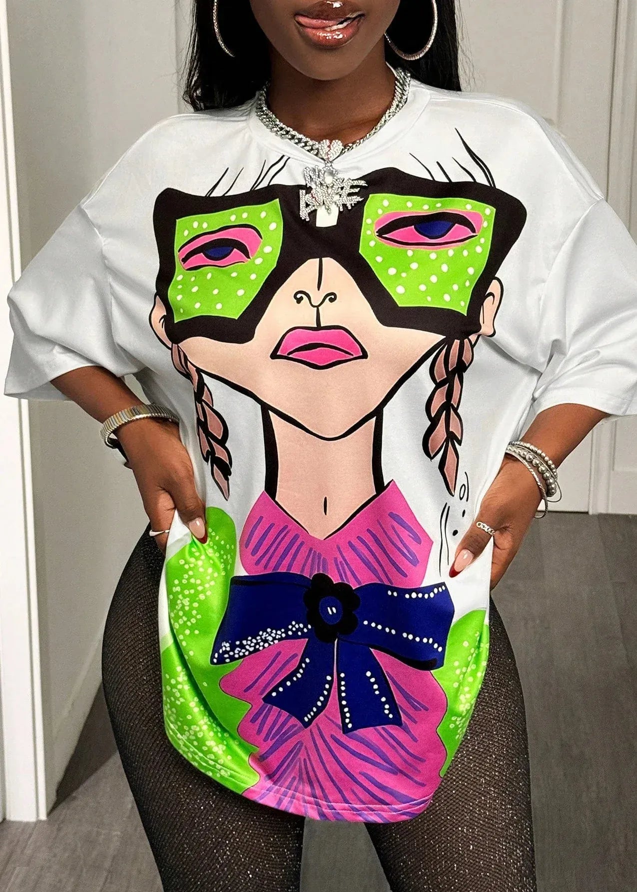 Person wearing a white t-shirt with a colorful graphic design of a woman wearing a mask.