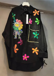 Black shirt with colorful floral and animal designs on a hanger against a neutral background
